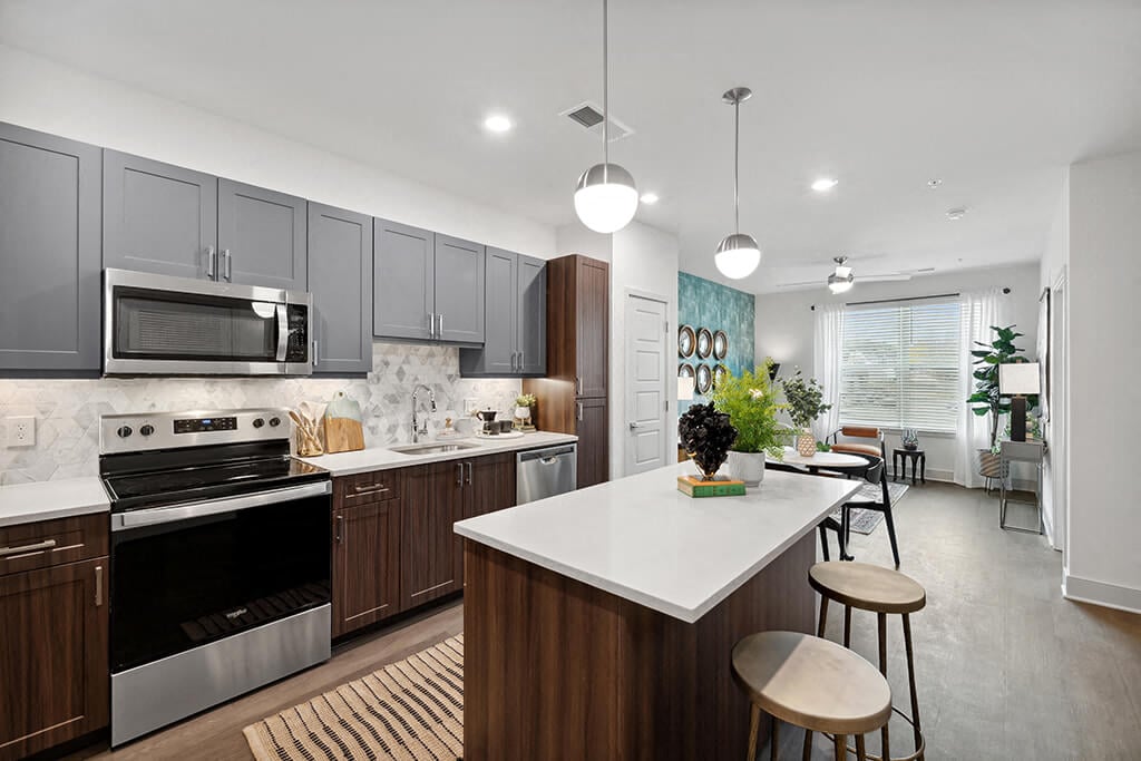 A modern kitchen with dark cabinets and a kitchen island at The Belhaven Apartments in Alexandria, Virginia.
